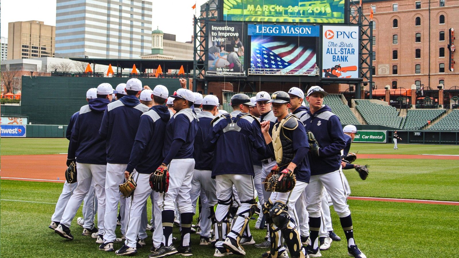 Navy players huddled on the field at Oriole Park at Camden Yards