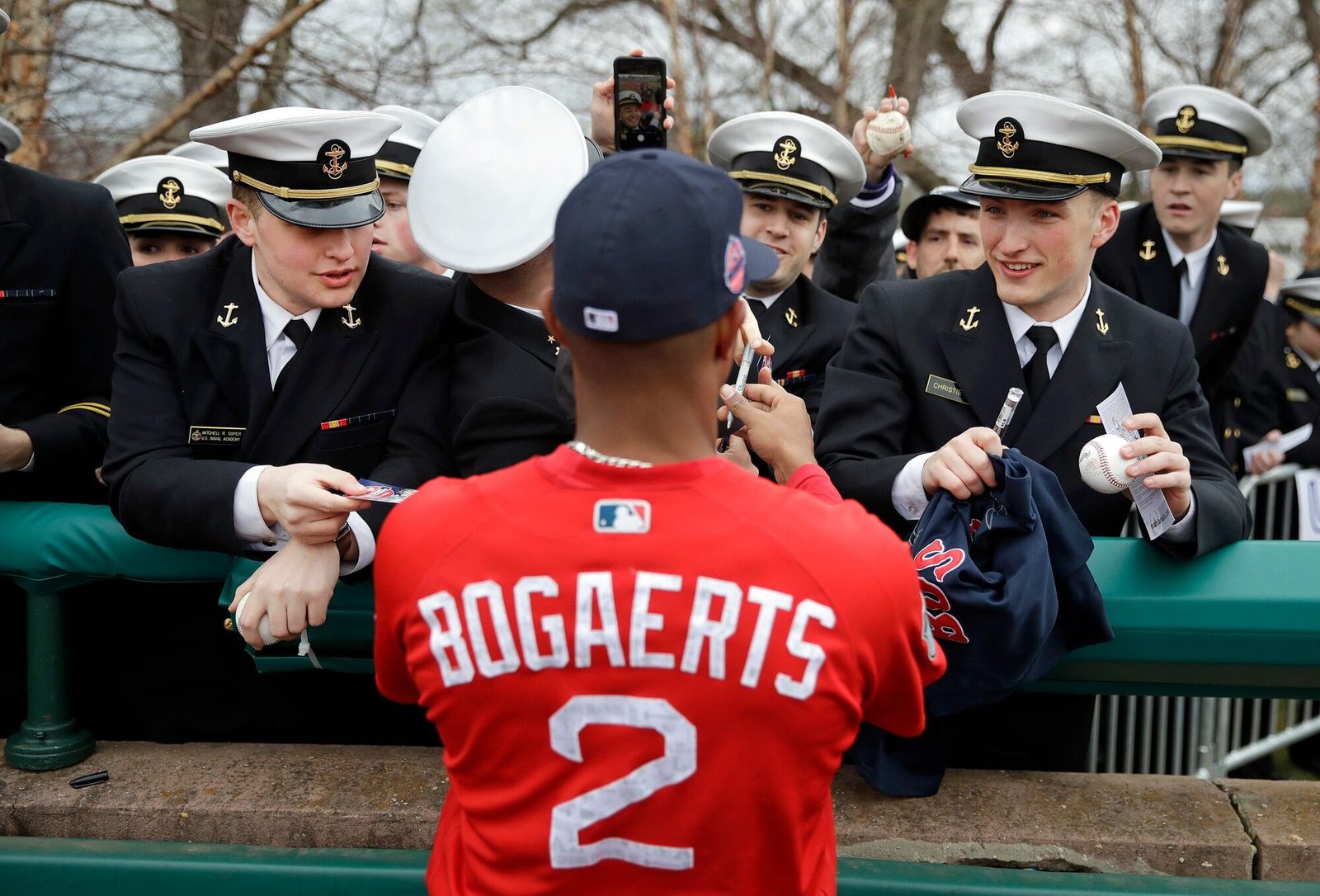 Xander Bogaerts signing autographs along the rail for midshipmen in uniform