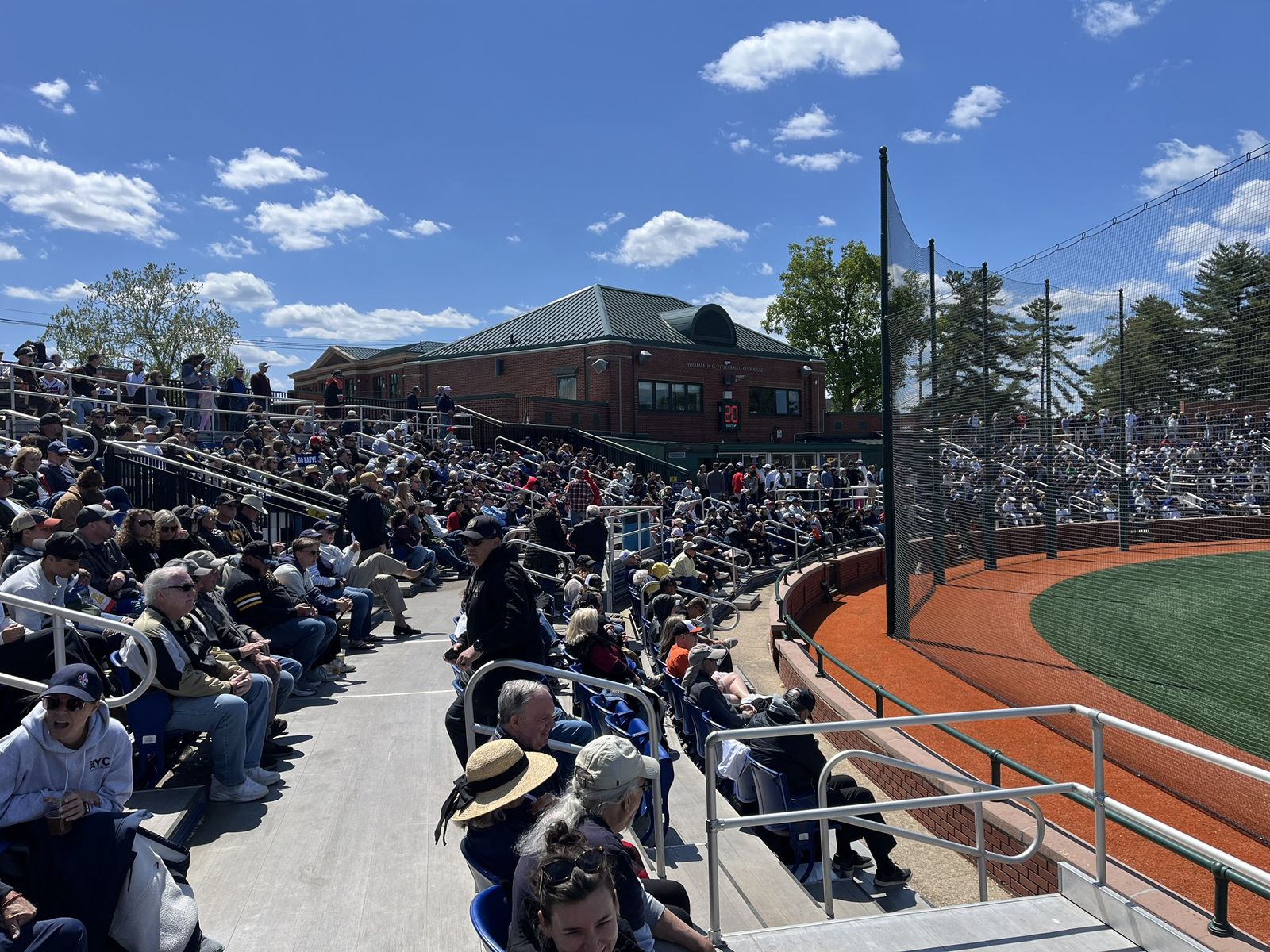View from inside the packed stands out toward the field under a blue sky